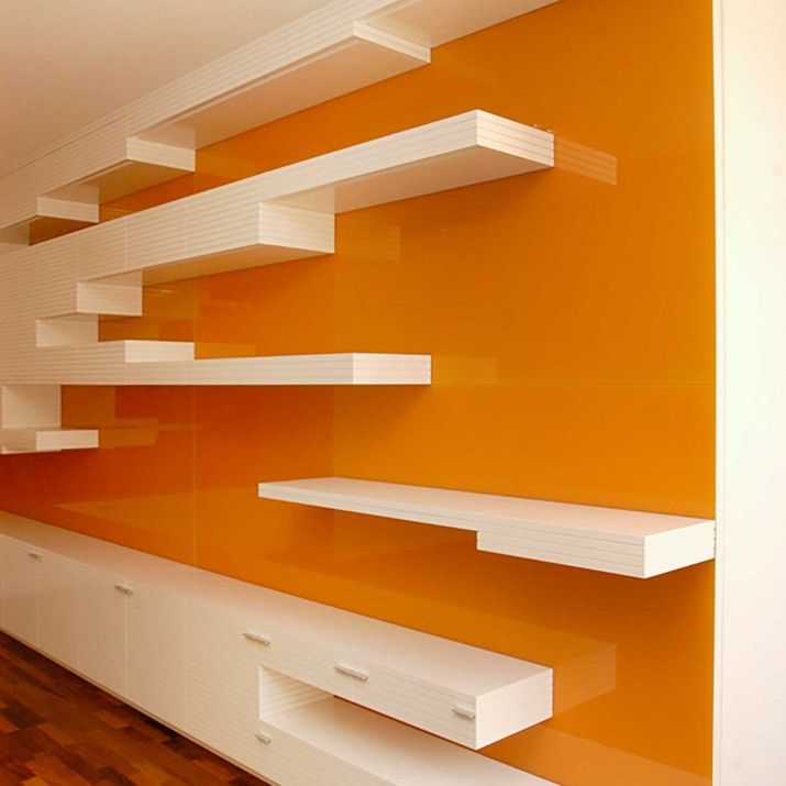 Byt Praha 1 - obývací stěna v lakované bílé barvě v kombinaci s oranžovým sklem.