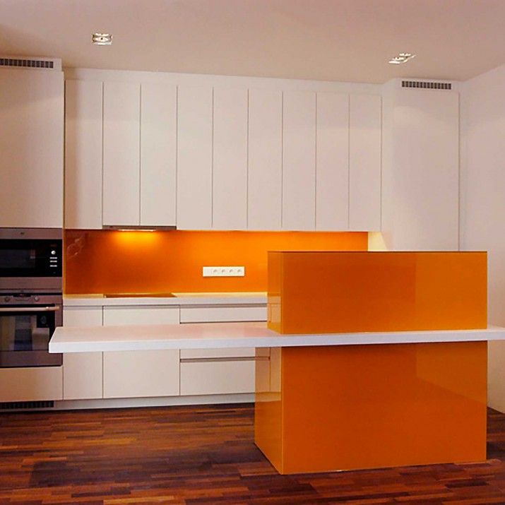 Byt Praha 1 - Kuchyně bíle lakovaná v kombinaci s oranžovým sklem.