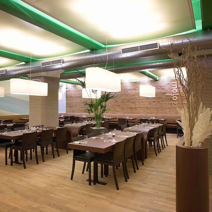 Restaurace Mollo 22 Praha Holešovice - ohýbané stoly, čalouněné lavice a kulaté květináče.