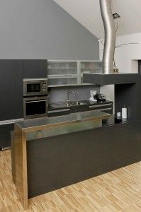 Rodinný dům Kostelec u Křížku - kuchyně z tmavého laminátu se zajímavým odvodem digestoře.