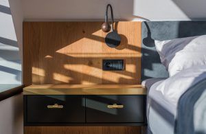 Apartmán Špindlerův Mlýn – Detail nočního stolku se stěnou obloženou dřevem