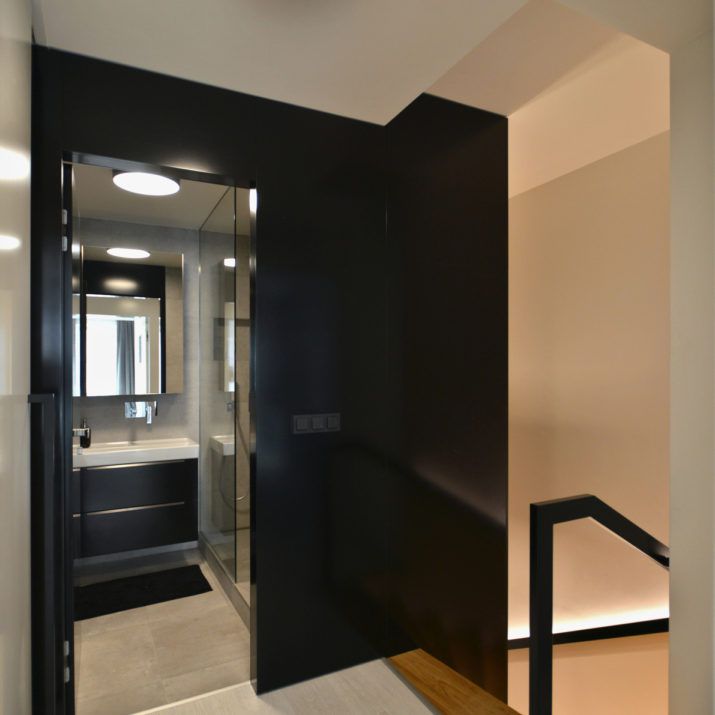 Byt praha - Černý obklad stěn s dveřmi do koupelny.